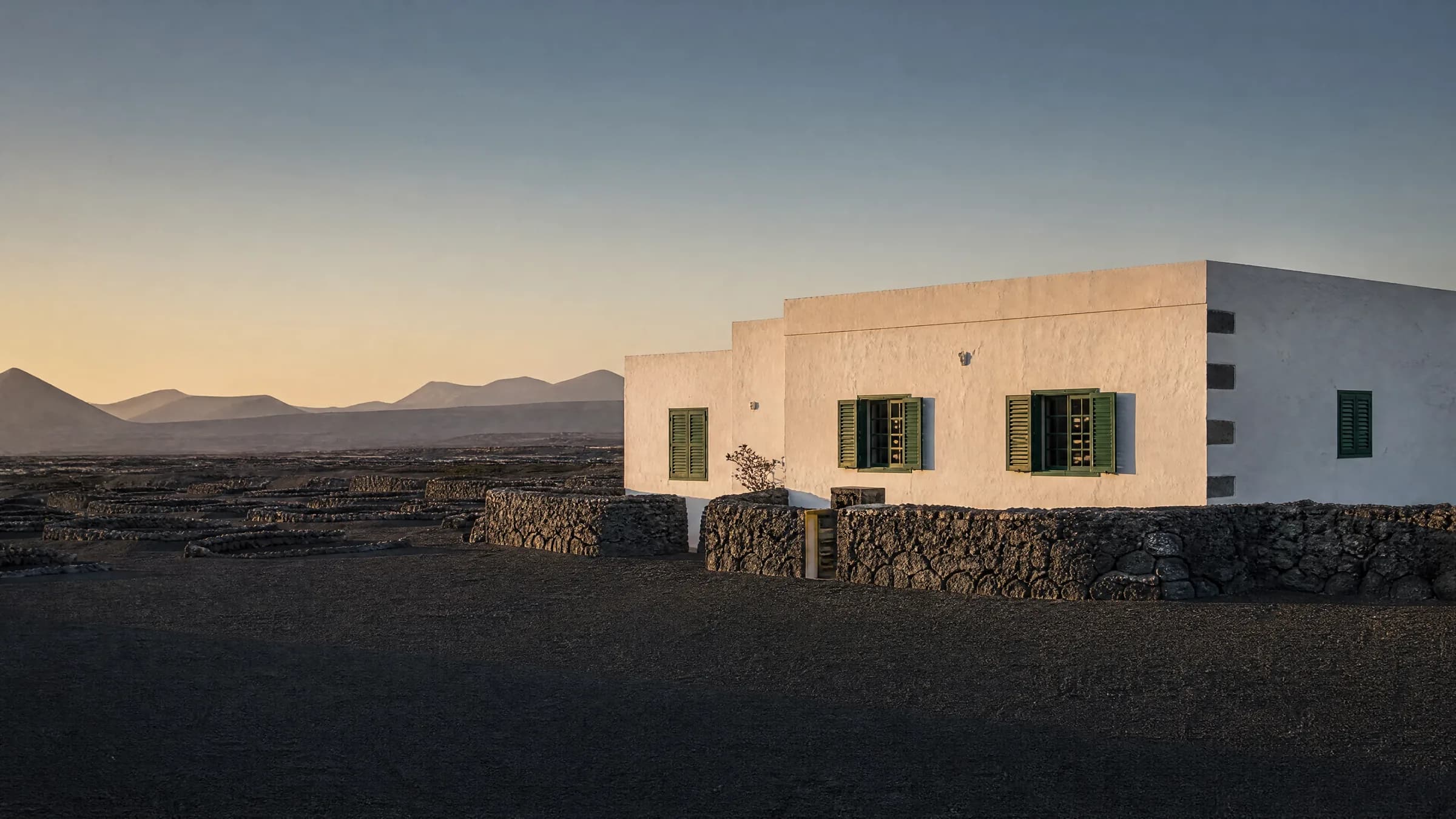 Casa de piedra volcánica en La Geria, Lanzarote, al atardecer